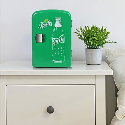 Green Sprite-themed mini fridge on a white dresser with a potted plant