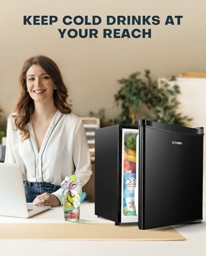 Woman sitting at desk with open mini fridge containing drinks.