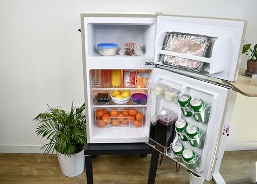 Open refrigerator with fruits, vegetables, drinks, and food containers.